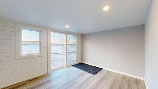 spare room with recessed lighting, wood finished floors, visible vents, and baseboards