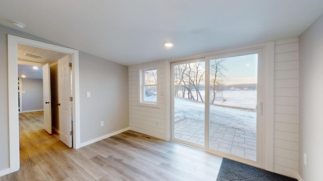 entryway featuring a water view, light wood finished floors, baseboards, and recessed lighting