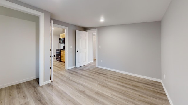 unfurnished bedroom featuring light wood-style floors, baseboards, and recessed lighting