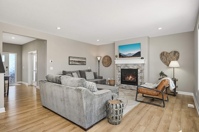 living room with a fireplace and light hardwood / wood-style flooring