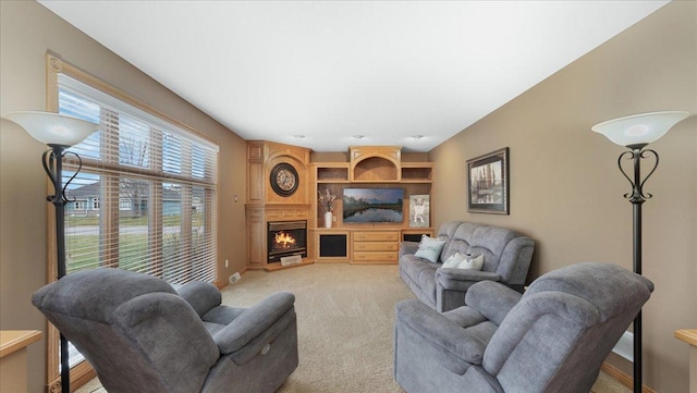 living room featuring light carpet, a fireplace, and baseboards