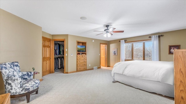 bedroom with a closet, visible vents, a ceiling fan, light carpet, and baseboards