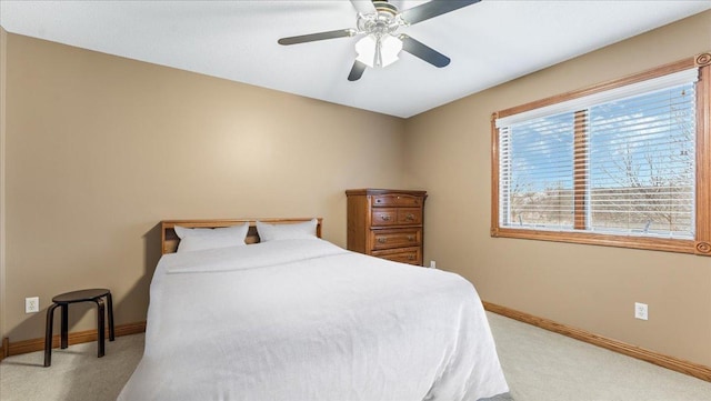 bedroom with light carpet, baseboards, and a ceiling fan