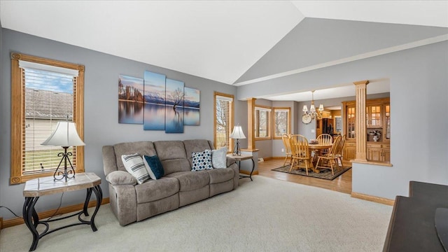 carpeted living area with a healthy amount of sunlight, a notable chandelier, and baseboards