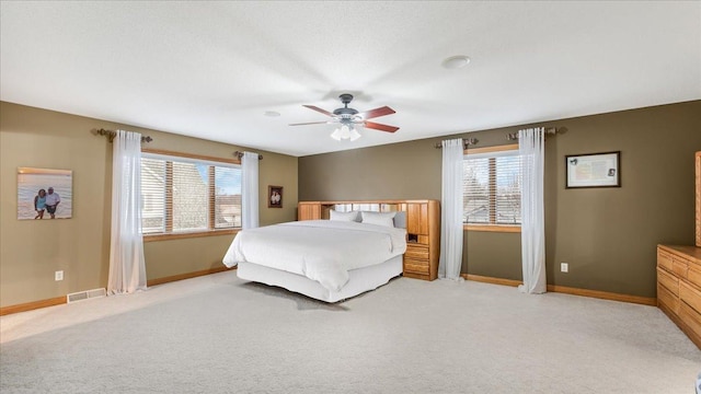 bedroom with light colored carpet, baseboards, a ceiling fan, and visible vents
