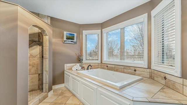 bathroom with a tile shower, tile patterned flooring, and a garden tub