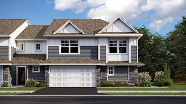 view of property featuring a shingled roof, stone siding, aphalt driveway, an attached garage, and board and batten siding