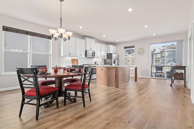 dining space featuring light hardwood / wood-style flooring and a chandelier