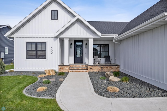 exterior space featuring a porch, board and batten siding, and roof with shingles