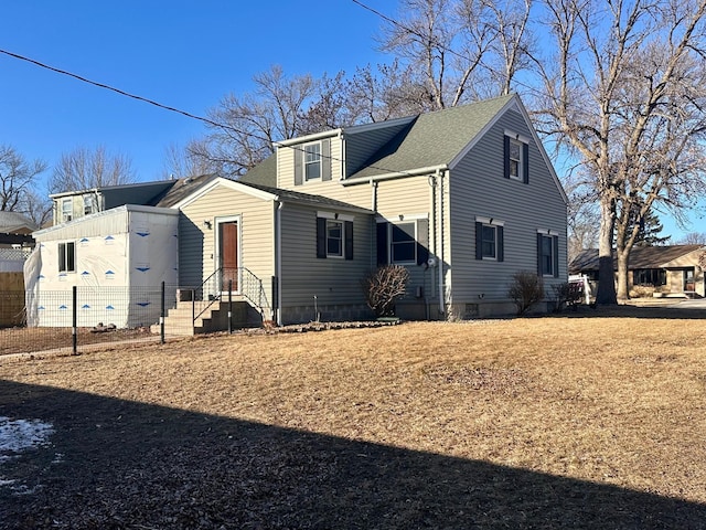 view of home's exterior featuring fence and a shingled roof