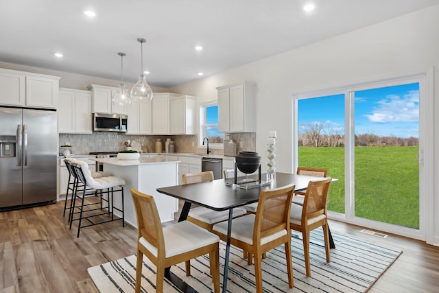 dining area with sink and light hardwood / wood-style floors