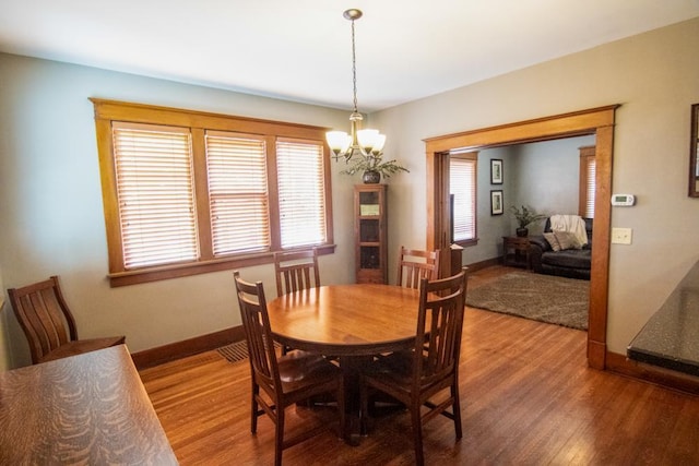 dining room featuring hardwood / wood-style flooring, a notable chandelier, and a wealth of natural light