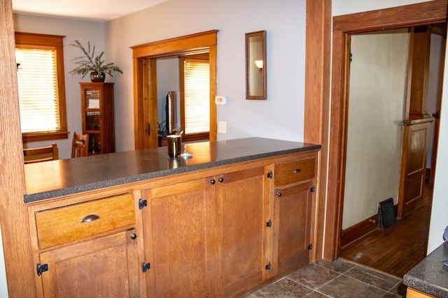 kitchen with kitchen peninsula and dark tile patterned floors