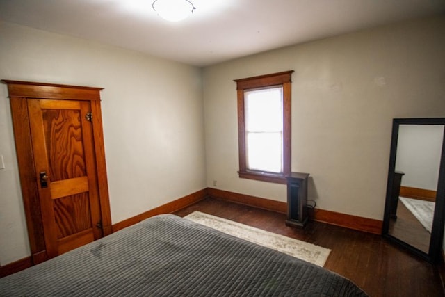 bedroom with dark hardwood / wood-style flooring