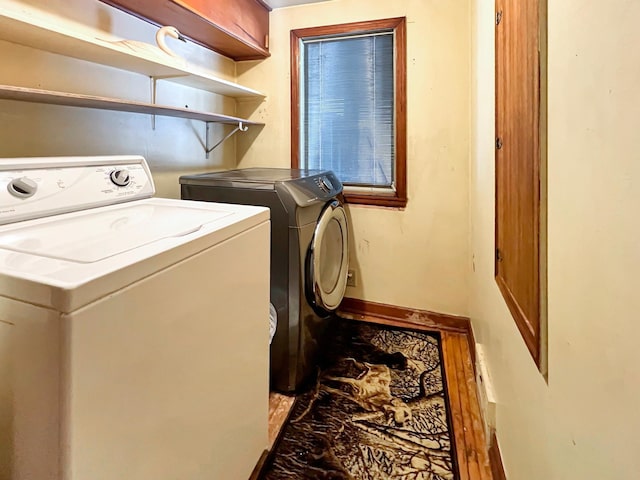 clothes washing area featuring separate washer and dryer and cabinets