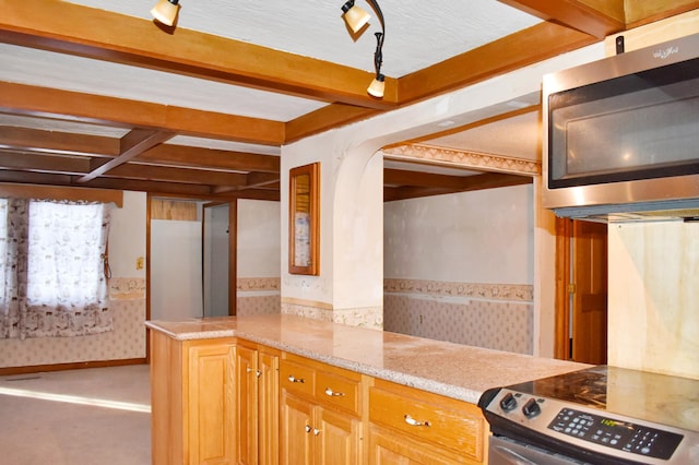 kitchen featuring appliances with stainless steel finishes, beamed ceiling, arched walkways, and light stone countertops