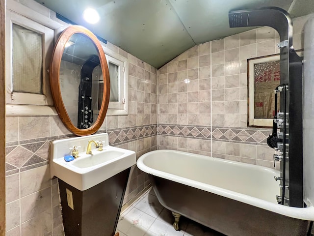 full bath with a freestanding tub, tile walls, lofted ceiling, and vanity