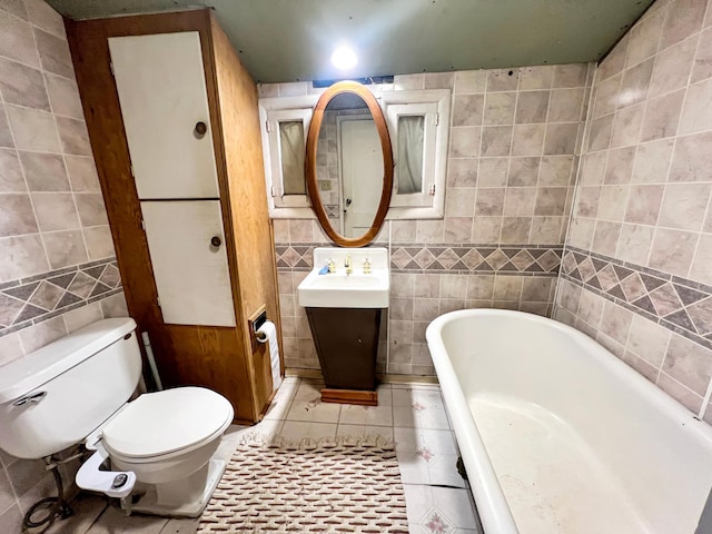 bathroom featuring tile walls, tile patterned floors, a soaking tub, and toilet
