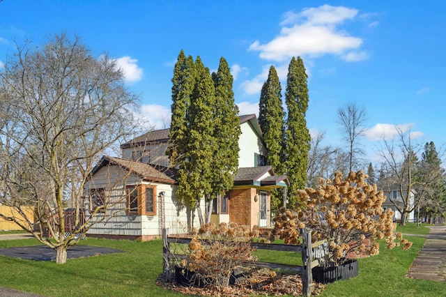 view of front of home featuring roof with shingles, fence, and a front yard