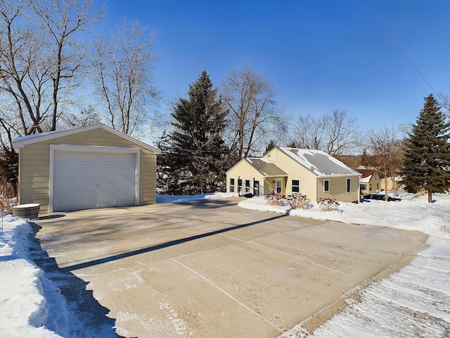 view of front of home featuring driveway, a garage, and an outdoor structure