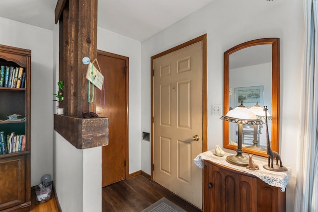 foyer entrance featuring dark wood-type flooring and baseboards