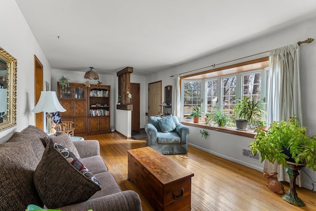 living area featuring visible vents, wood-type flooring, and baseboards