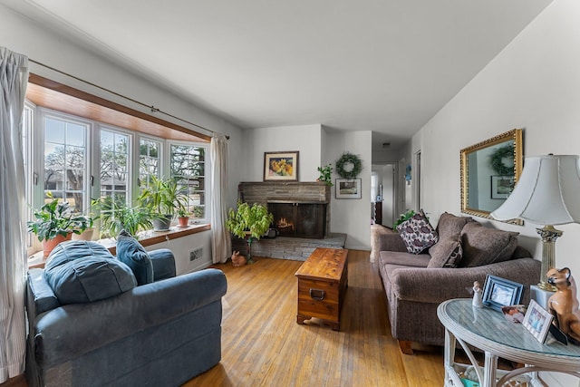 living room featuring a fireplace, lofted ceiling, and hardwood / wood-style floors