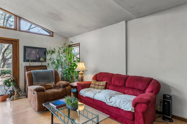 living area with lofted ceiling, a textured ceiling, and wood finished floors