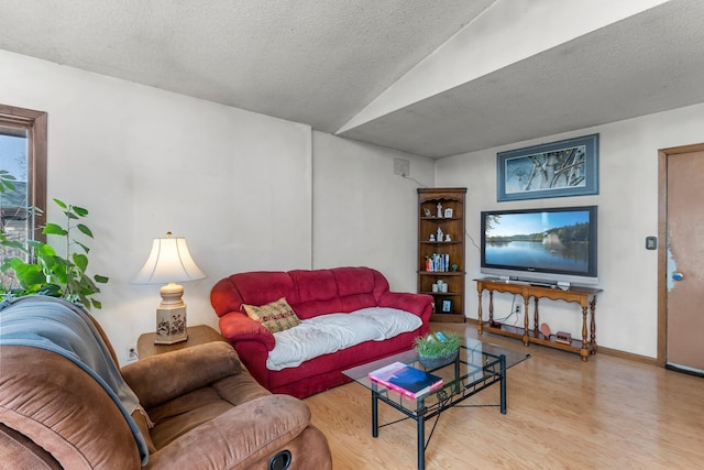 living area featuring baseboards, a textured ceiling, and wood finished floors