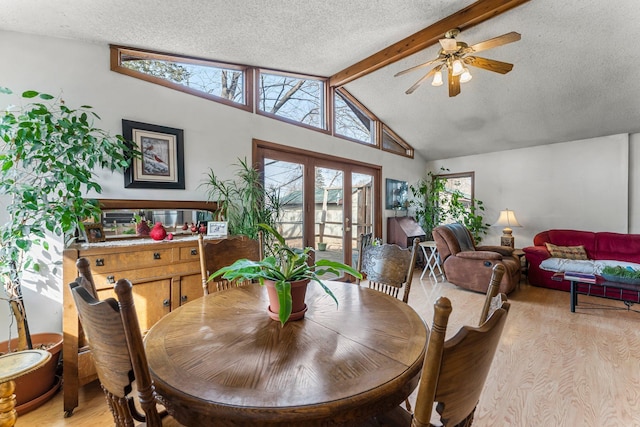 dining area with french doors, plenty of natural light, light wood-style floors, and vaulted ceiling with beams