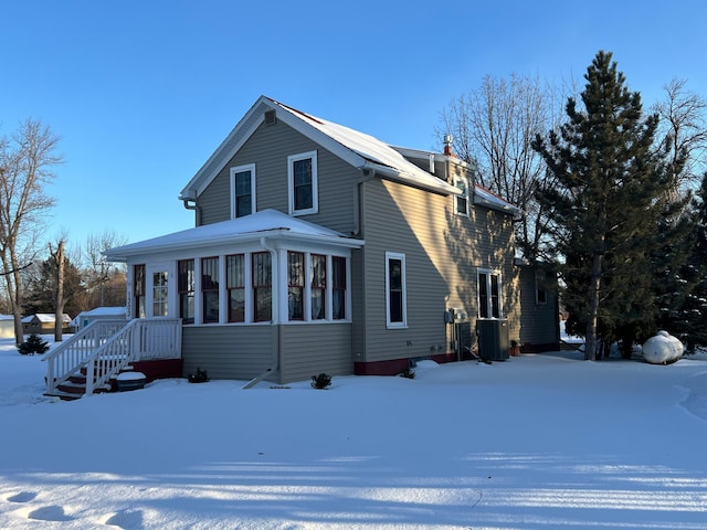 view of front of property featuring central AC unit and a sunroom