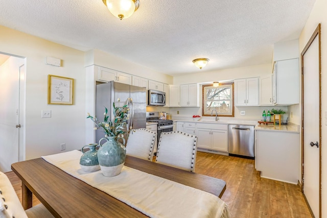 interior space with light hardwood / wood-style flooring, sink, and a textured ceiling