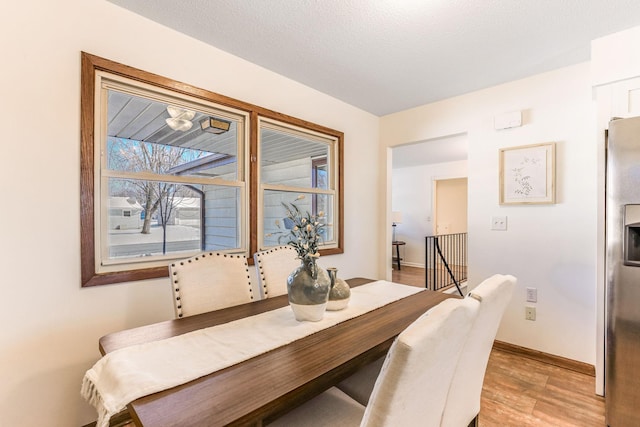 dining area featuring a textured ceiling and light hardwood / wood-style floors