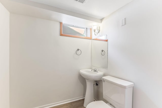 bathroom featuring hardwood / wood-style flooring and toilet