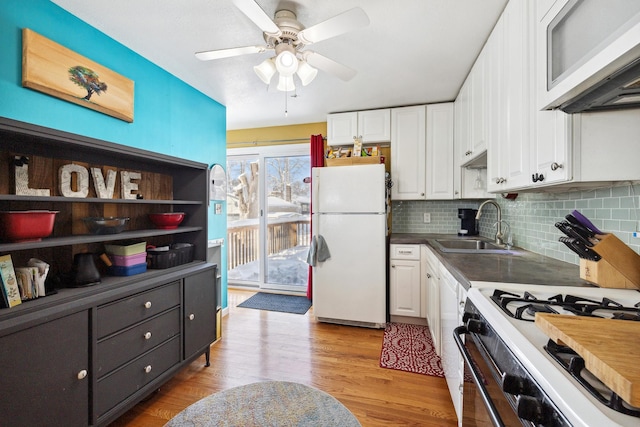 kitchen featuring white appliances, white cabinets, light wood-style flooring, and a sink