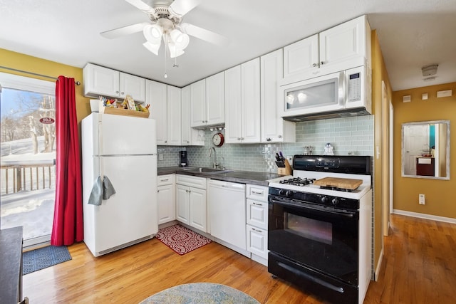 kitchen with white appliances, light wood-style flooring, a sink, white cabinetry, and backsplash