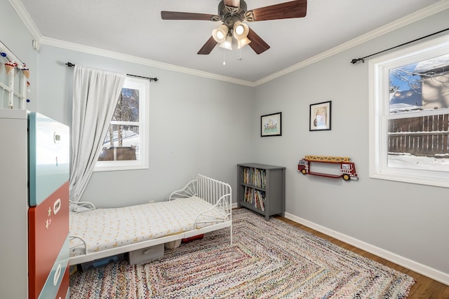 bedroom with a ceiling fan, wood finished floors, baseboards, and ornamental molding