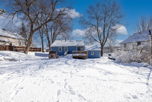 snow covered property featuring fence and a wooden deck