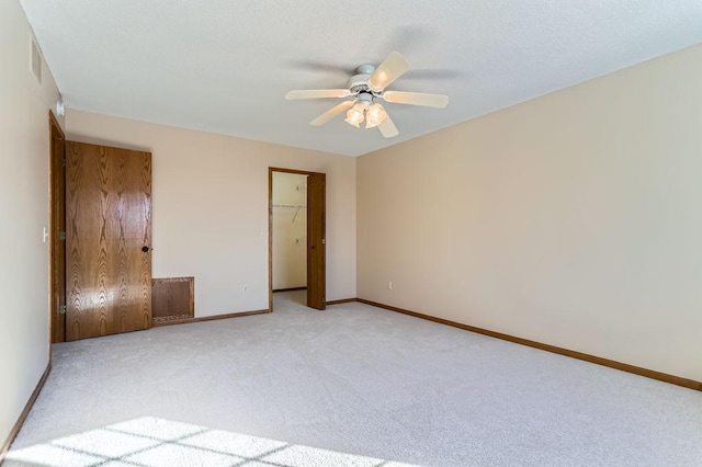 unfurnished bedroom with light carpet, ceiling fan, a closet, and baseboards