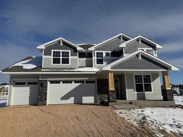 craftsman inspired home featuring a porch, stone siding, an attached garage, and dirt driveway