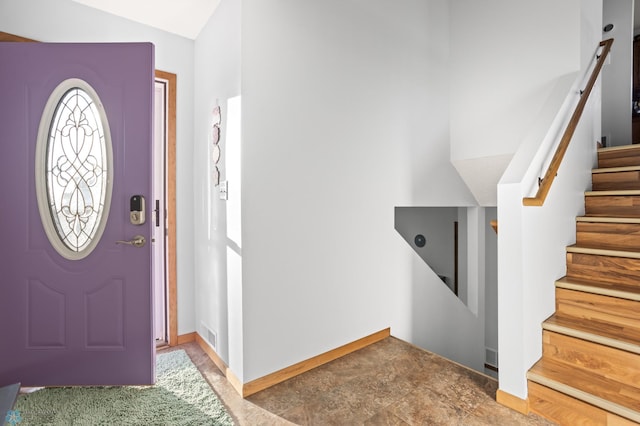 foyer featuring visible vents, stairway, and baseboards