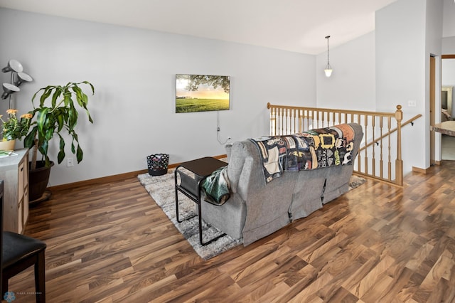 living room featuring baseboards, vaulted ceiling, and wood finished floors