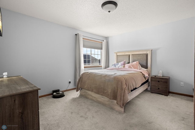 bedroom featuring light colored carpet, a textured ceiling, and baseboards