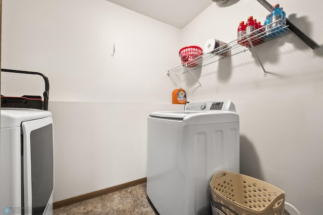 laundry room featuring laundry area, baseboards, and washing machine and clothes dryer