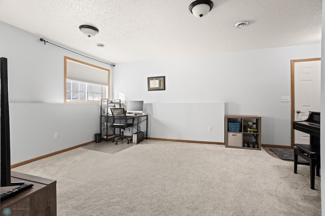 office featuring a textured ceiling, carpet floors, and baseboards