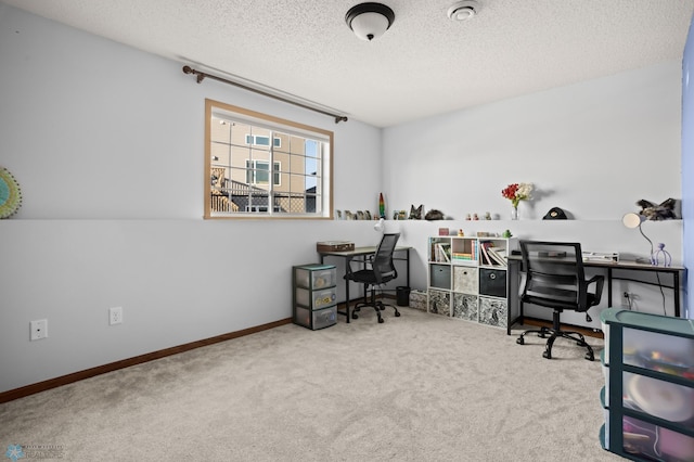 office area with carpet, baseboards, and a textured ceiling