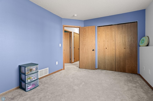 unfurnished bedroom featuring carpet flooring, visible vents, and baseboards