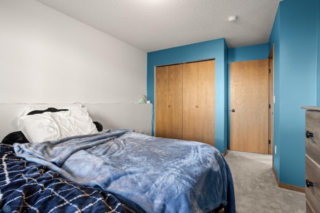 carpeted bedroom with a textured ceiling and a closet