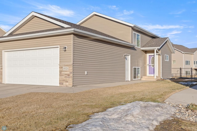 view of front of house with a shingled roof, concrete driveway, entry steps, fence, and a garage