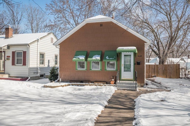 bungalow featuring fence